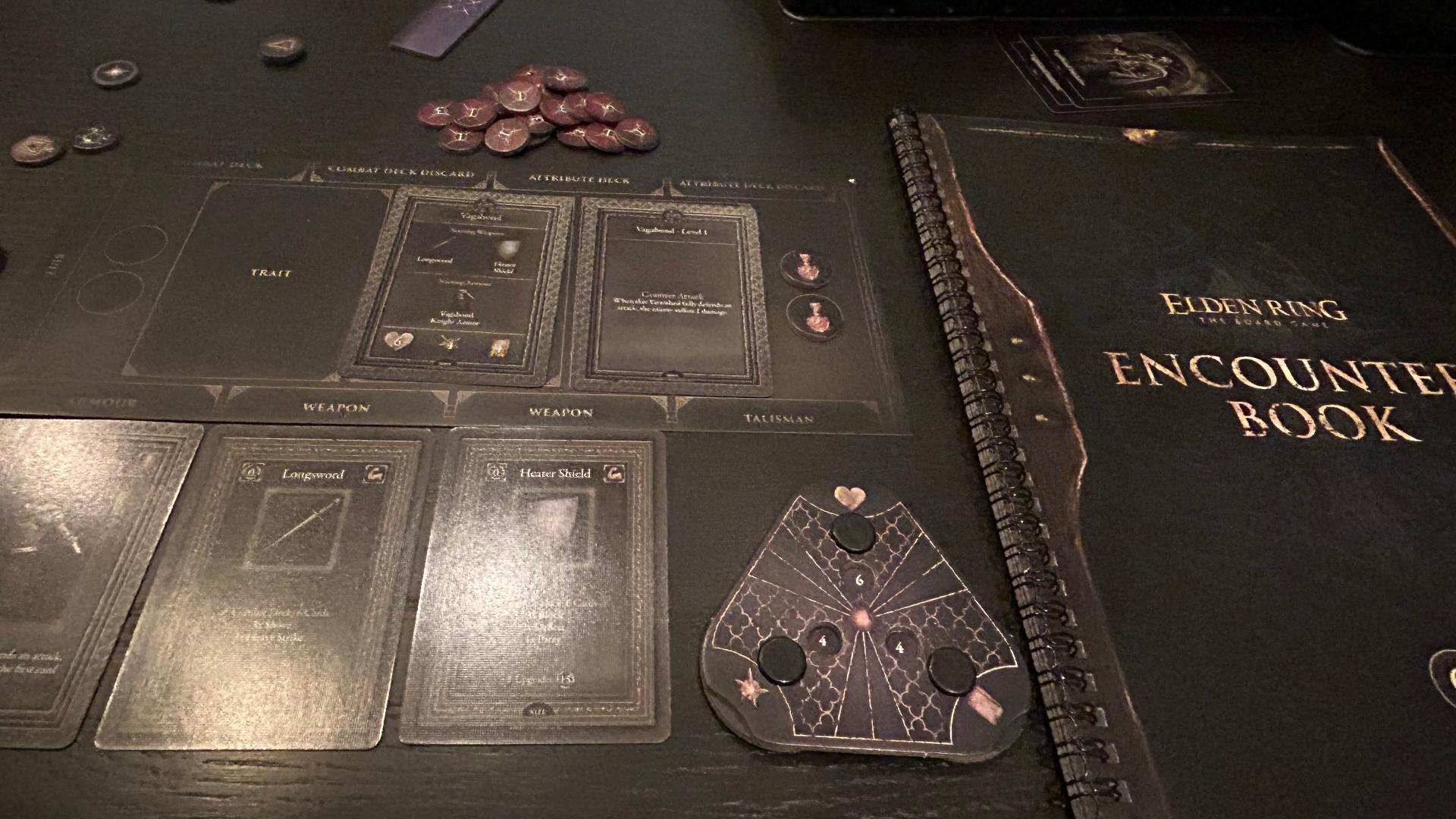 Elden Ring: The Board Game - Realm of the Grafted King cards, components, and book on a dark table