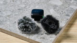 The DJI Mic Mini in black on a stone surface.