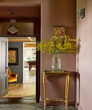 hallway with dusky pink wall and small gold console table