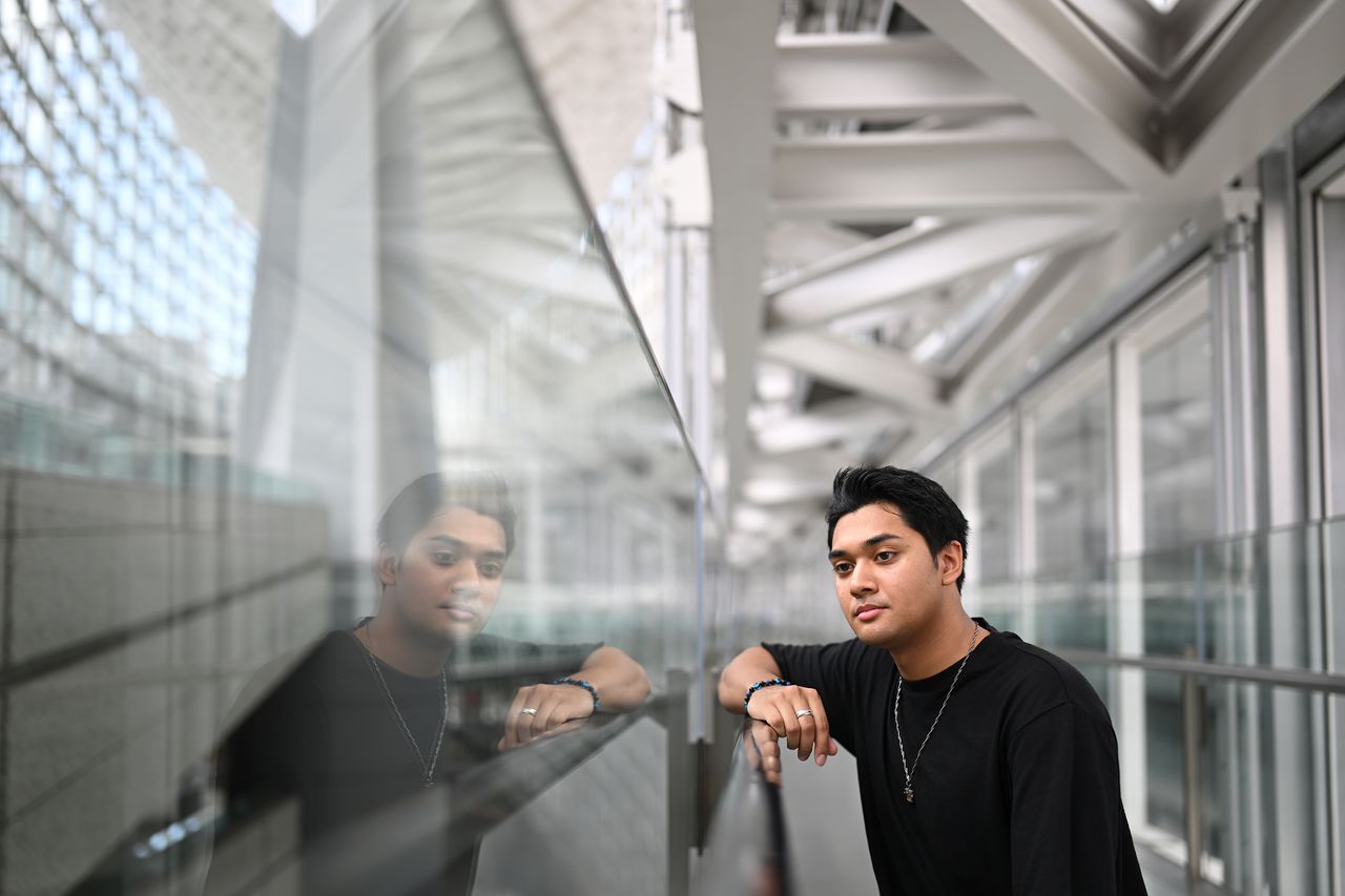 Sample image taken with a Nikon Z 35mm f/1.2 S lens showing a man and his reflection in a modern glass building