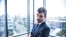 Frowning businessman standing next to office window