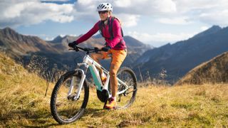 woman using e-bike to cycle on hill