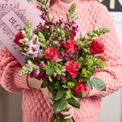 girl with bouquet and card in hand