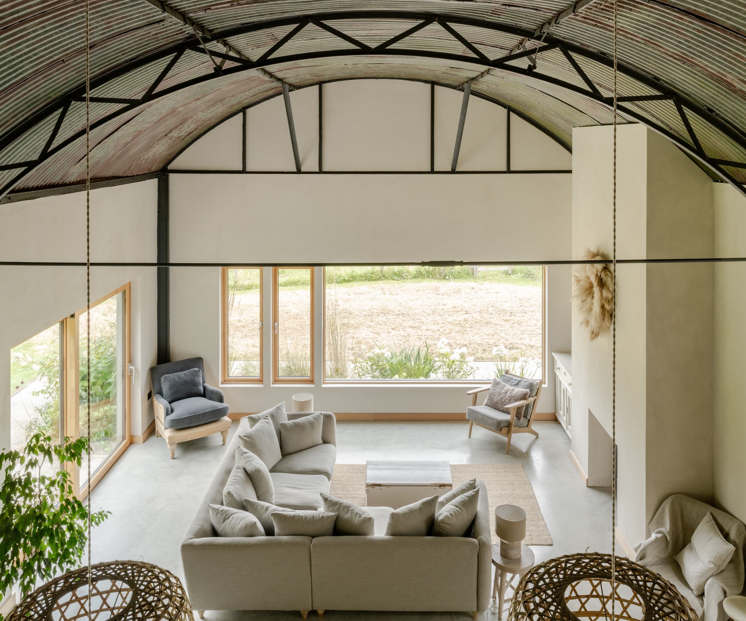 A mezzanine overlooking a living area with picture windows