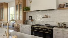 A neutral kitchen with a tiled backsplash and natural stone countertops