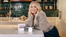 Hilary Duff at in a green kitchen at the counter posing next to the Below 60° diffusers