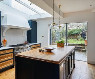 open plan kitchen extension with roof light above blue and wood kitchen island