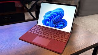 Microsoft Surface Pro 9 in red on a wooden table