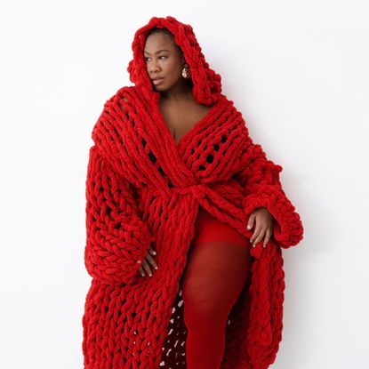 Kelly Augustine in a red sweater coat and red tights