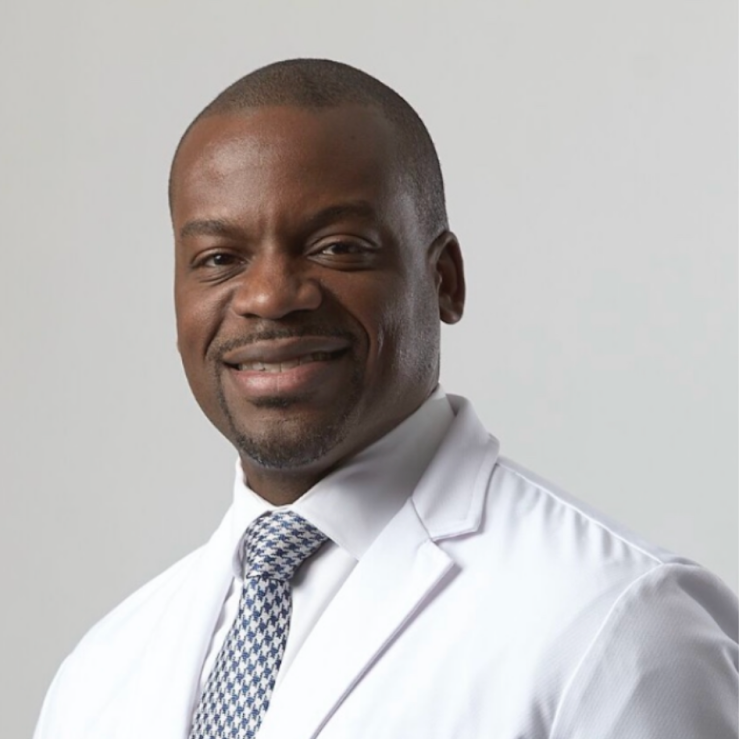 Head and shoulders of man wearing tie and a white doctor&rsquo;s coat