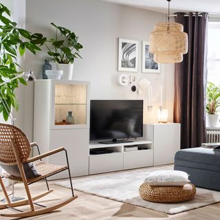 living room with white walls tv unit with white cabinet and wooden flooring
