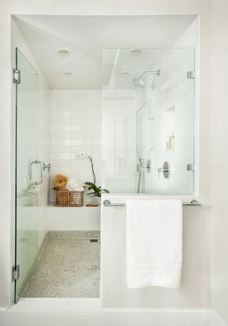 Shower with white tile walls and neutral floor