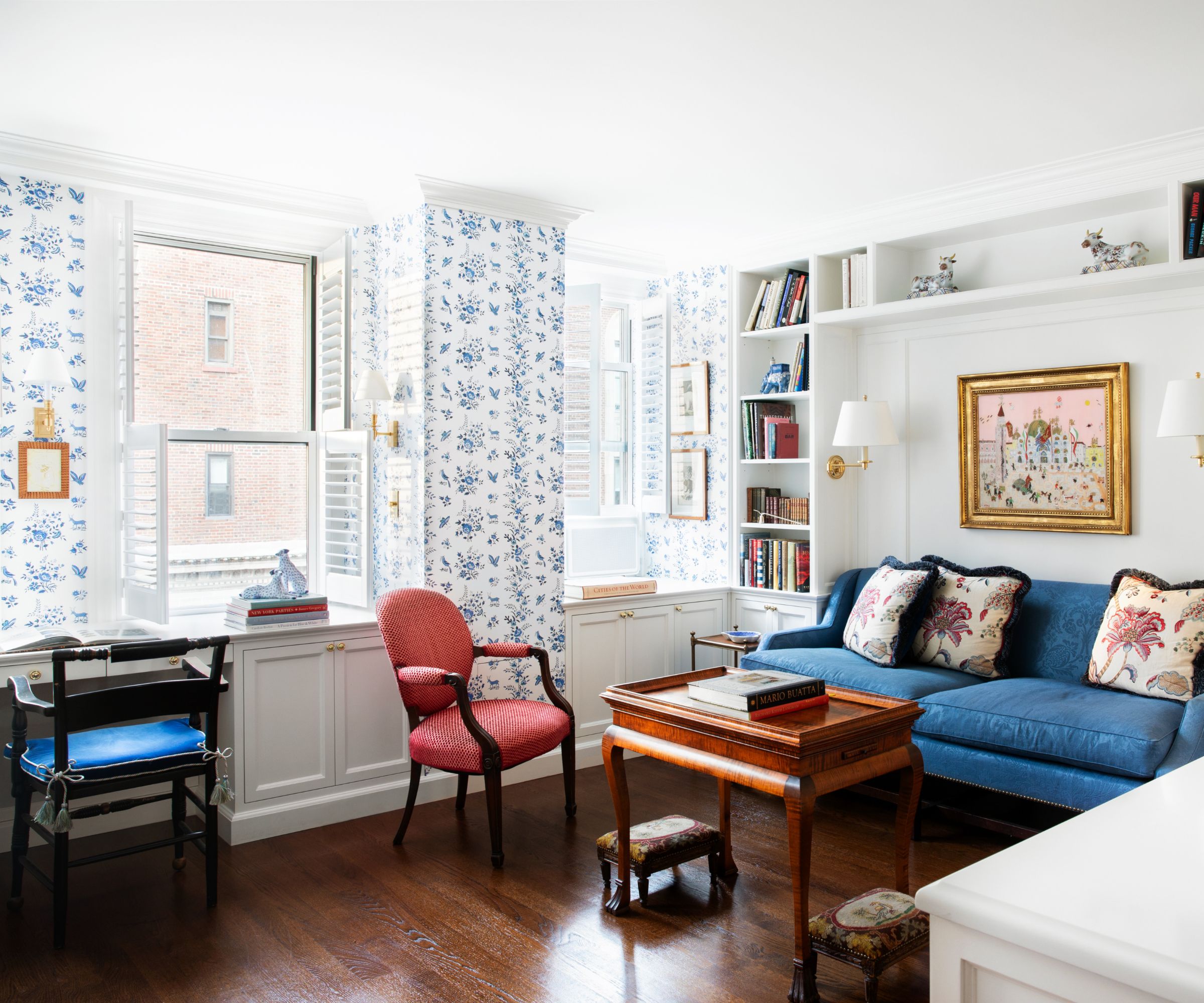 A blue and white living room connected to an L-shaped kitchen via a peninsula