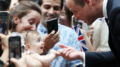 8 month old Albane Costa holds the finger of Prince William, Prince of Wales during his visit to the HSBC Rain Vortex at Jewel Changi Airport on day one of his visit to Singapore on November 05, 2023 in Singapore.