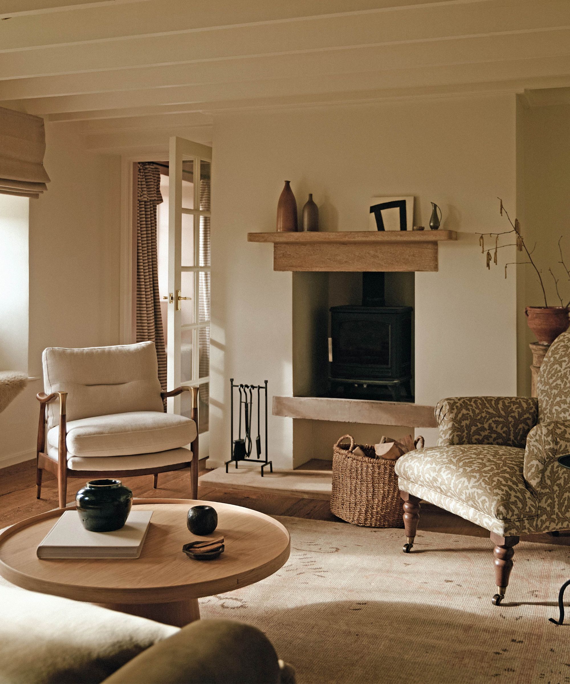 a neutral cottage living room with traditional fireplace, paneled ceiling and a mix of wooden toned furniture and patterned accent chairs