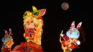 three colorful rabbit characters in front of full moon in background