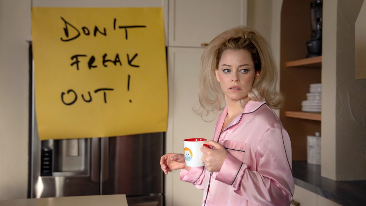Elizabeth Banks standing in front of a post-it that says 'Don't Freak Out' in The Miniature Wife