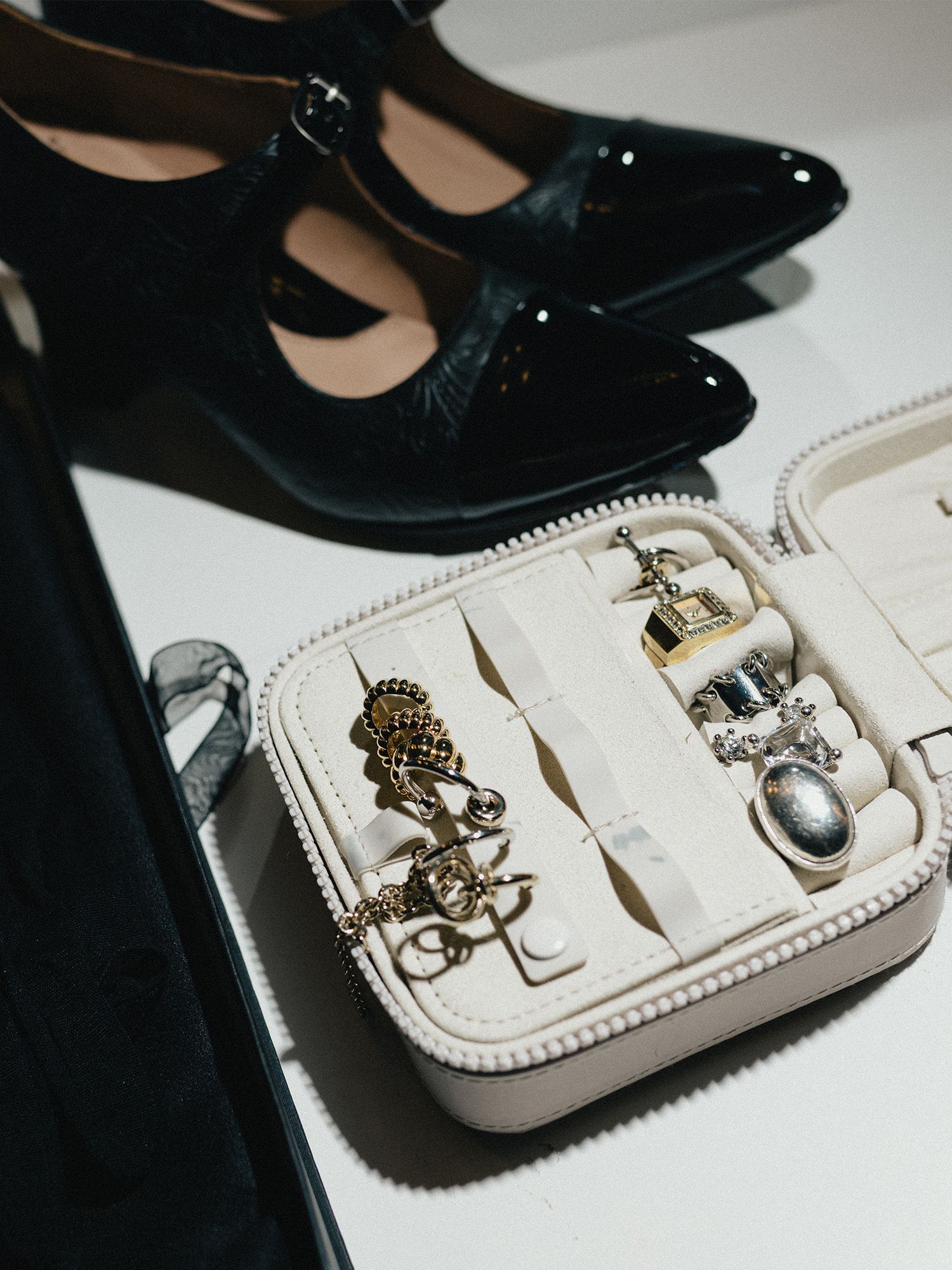 A photo of Gracie Lawrence's accessories for the 2025 Tony Awards. It's a pair of black patent leather Mary Jane shoes and an assortment of jewelry.