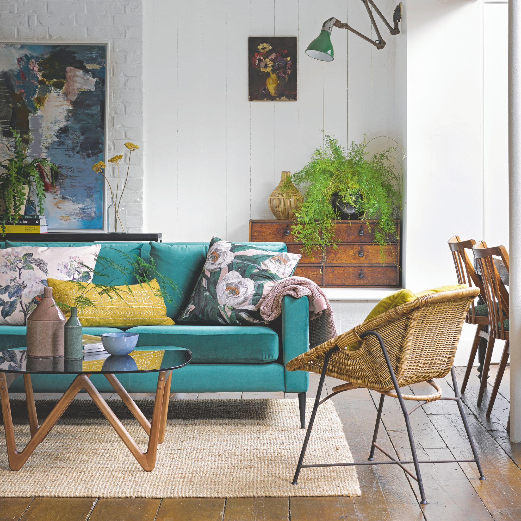 A blue accent sofa in a white living room, with floral cushions