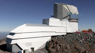 A white building sits on top of a rocky cliff