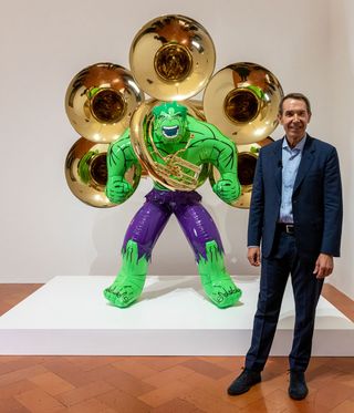 Portrait of artist Jeff Koons with his work, Hulk (Tubas), 2004-2018, installed in the exhibition 'Shine' at Palazzo Strozzi, Florence. 