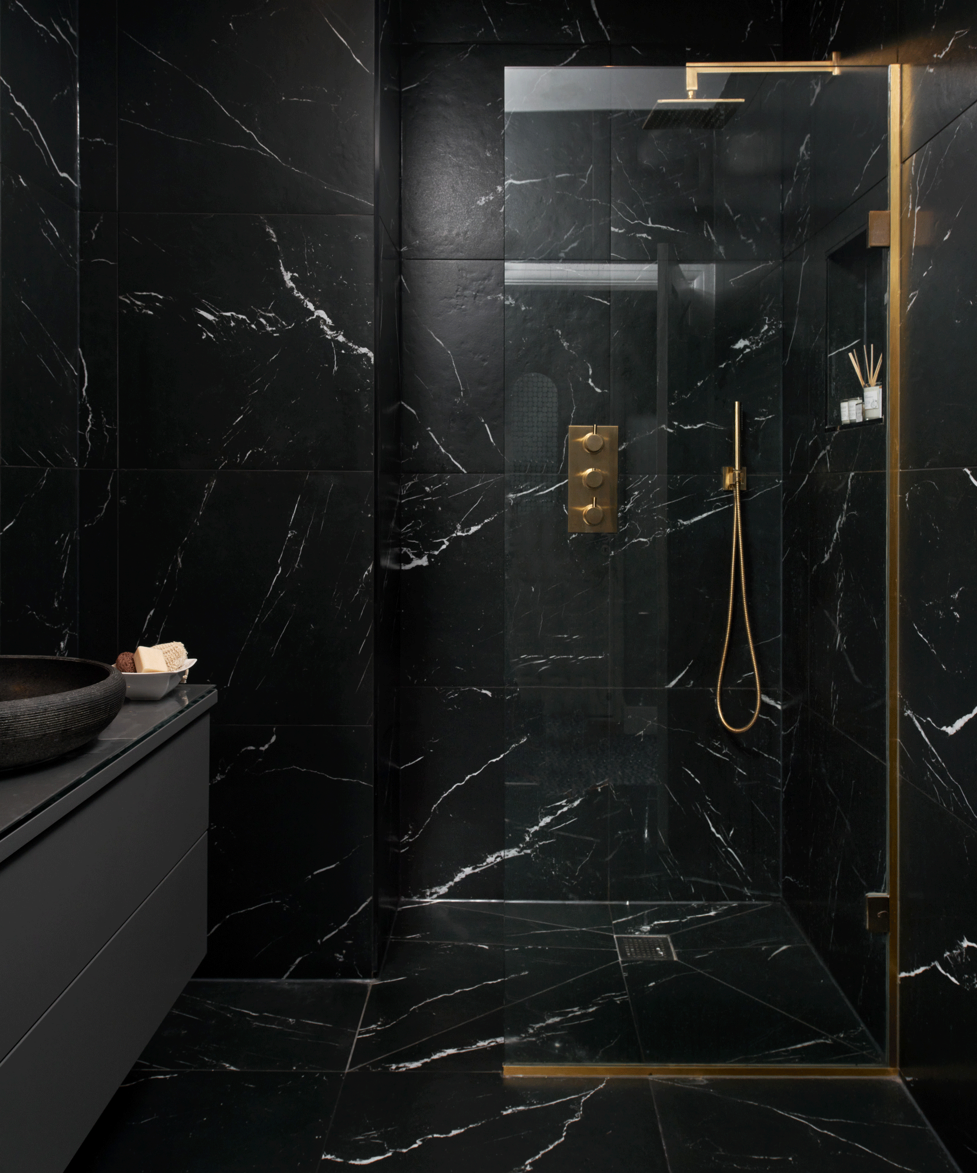 Black marble shower with gold accents