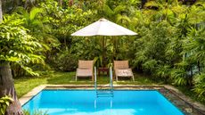 luxury swimming pool with loungers and parasol
