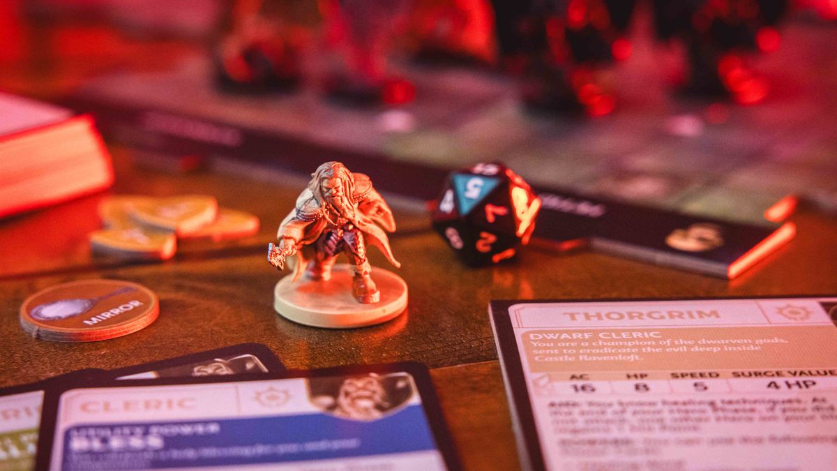 Castle Ravenloft board game components laid out on a dark table, with an ominous red glow on them