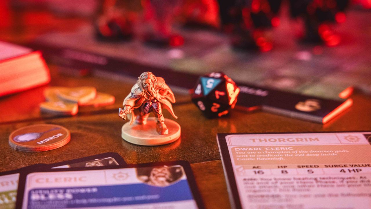 Castle Ravenloft board game components laid out on a dark table, with an ominous red glow on them