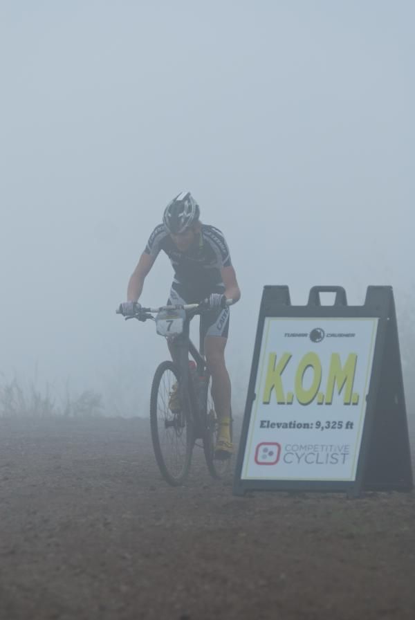 Cannondale Factory Team rider Alex Grant reaches the mist-shrouded summit and the Competitive Cyclist K.O.M. line.
