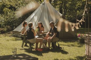 A group of campers sitting round a picnic table