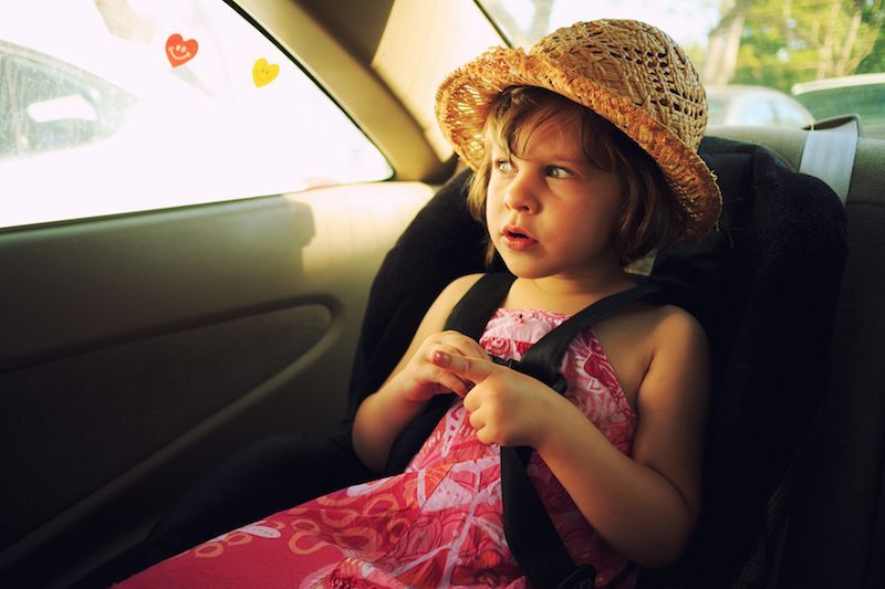 A young girl inside a car.