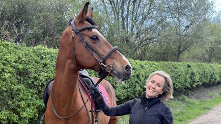Jojo Moyes with her bay horse, on a hedgelined driveway