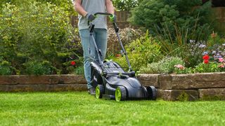 Gtech Cordless Lawnmower 2.0 being used by an adult human male to cut grass