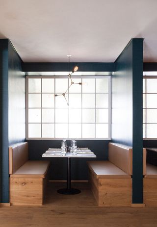 Italian Restaurant at copenhagen with teal blue walls and wooden seating bench