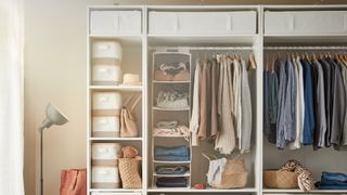 inside an organized small closet with lots of clothes with hanging rails, drawers and shelves filled with baskets