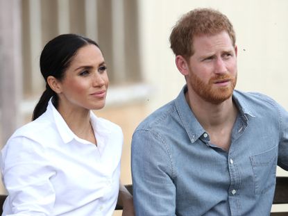 Prince Harry and Meghan Markle listen to a speech