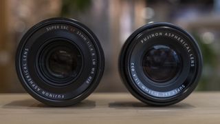 The Fujifilm XF33mm f/1.4 lens on a wooden table