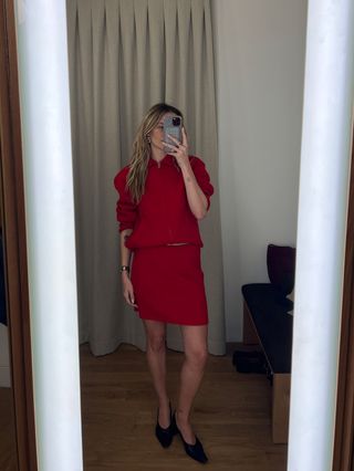 Eliza Huber in the dressing room at Madewell's new SoHo flagship in New York wearing a red jacket and skirt set.