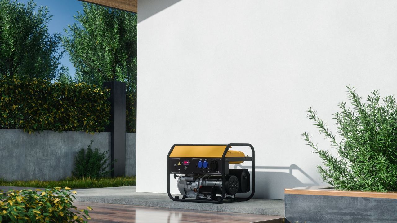 A black and yellow portable generator outside against a white painted house wall. 