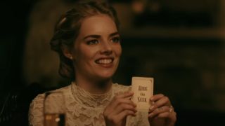 Samara Weaving as Grace holding up the "Hide and Seek" card in Ready or Not