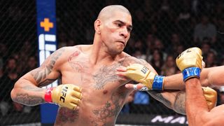 Tattooed, bald MMA fighter Alex Pereira of Brazil, wearing gold gloves, battles it out in the Octagon ring ahead of UFC 307: Pereira vs Rountree Jr.