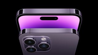 En iPhone 14 Pro visas upp fram- och bakifrån mot en svart bakgrund, med fokus på överdelen av mobilen.