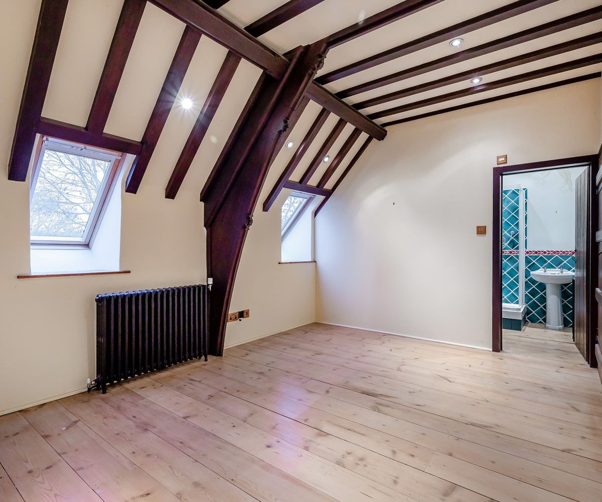 An empty, wooden floored bedroom
