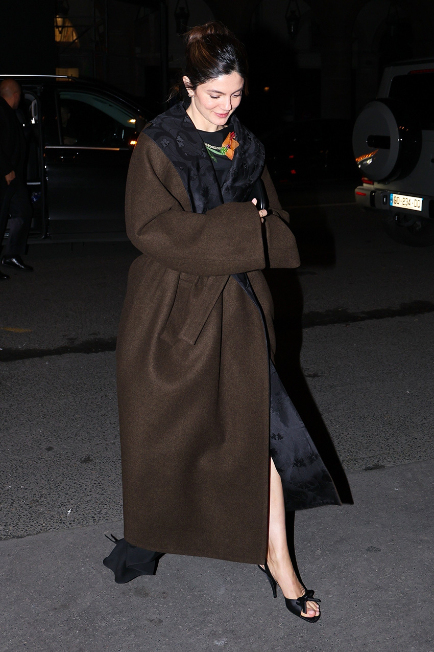 Monica Barbaro wearing a brown coat and bow shoes in Paris