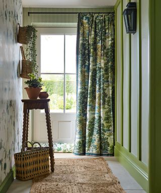 Green entryway with striped wallpaper and botanical curtains