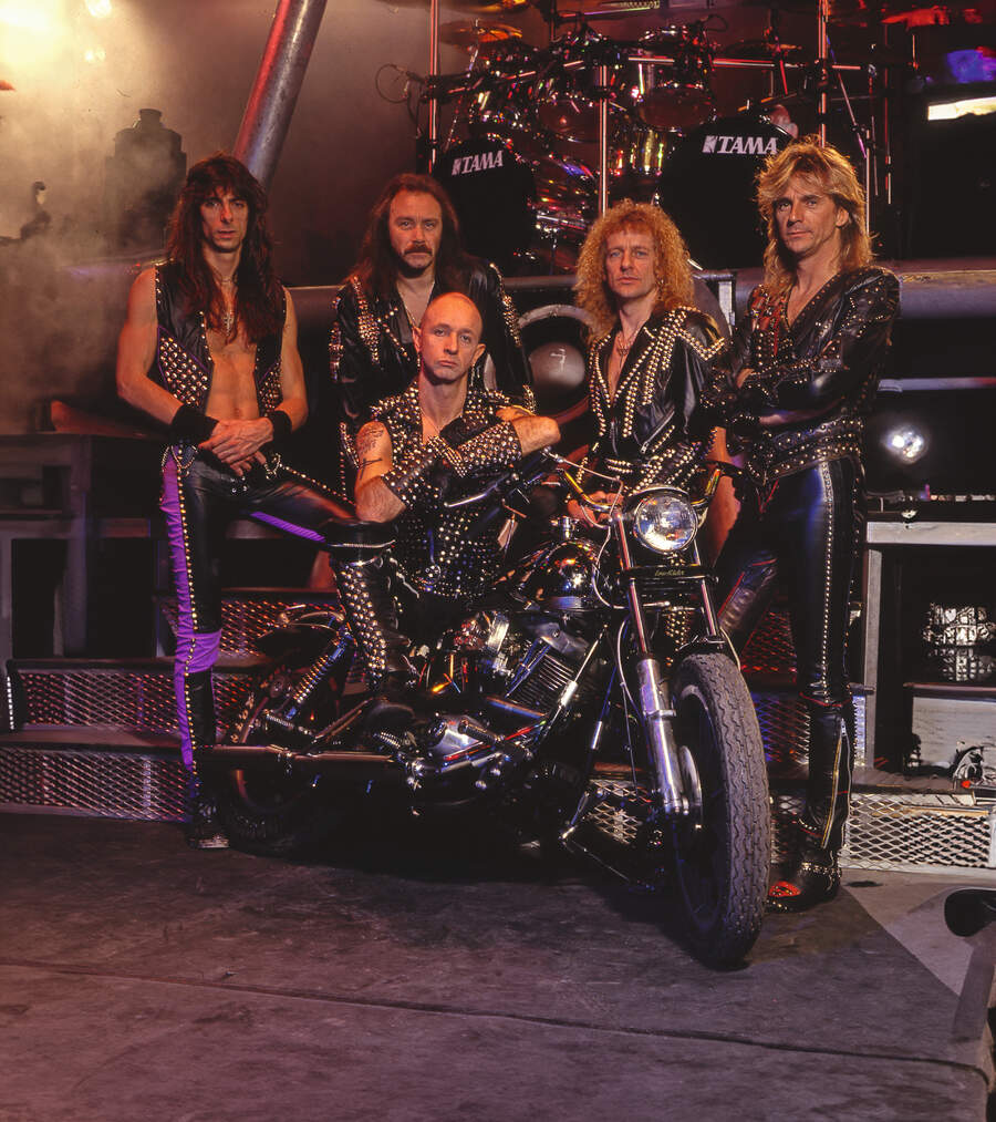 Judas Priest pose onstage around Rob Halford's motorbike