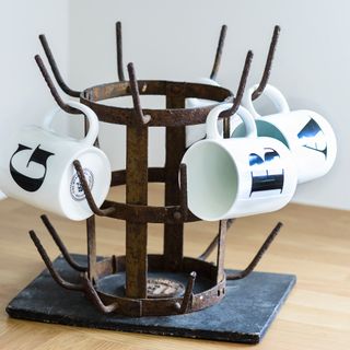 Rusted metal stand with holding alphabet mugs