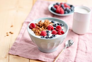 Yogurt with granola and berries in bowl - stock photo