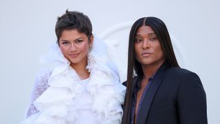 Zendaya with short hair and white frilly outfit posing next to Law Roach at Paris Fashion Week 2026